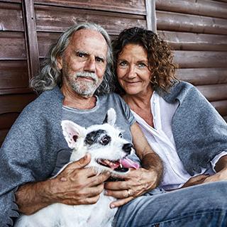 Man and woman sitting with a dog.